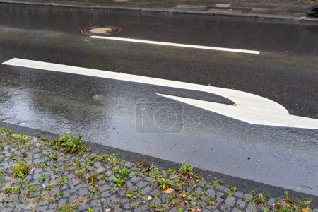 Photo for A closeup shot of turning road sign painted on the wet asphalt on rainy day - Royalty Free Image