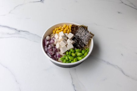Téléchargez les photos : Un délicieux poke bowl avec du tofu sur la table en marbre - en image libre de droit