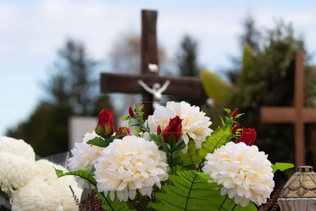 Photo for A close-up shot of flowers on gravestones in cemetery - Royalty Free Image