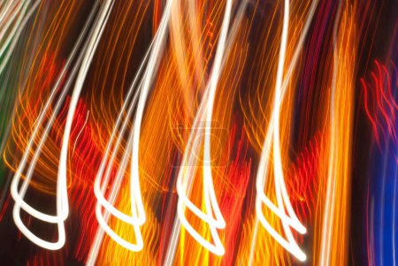 Foto de Bucle colorido brillante en su mayoría naranja y blanco larga exposición senderos de luz tomadas en el recinto ferial - feria de diversiones . - Imagen libre de derechos