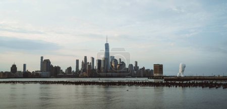 Photo for A beautiful view of One World Trade Center in New York City with a calm sea under a cloudy sky - Royalty Free Image