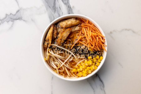 Téléchargez les photos : Une vue de dessus d'un délicieux poke bowl avec viande et maïs servi sur la table en marbre - en image libre de droit
