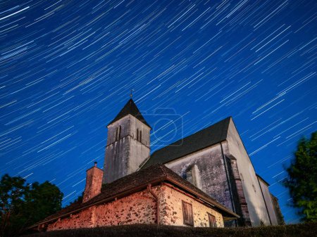 Foto de Un plano de ángulo bajo de una iglesia en la cumbre de Magdalensberg en Carintia, bajo el cielo lleno de estrellas - Imagen libre de derechos