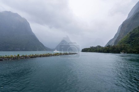 Téléchargez les photos : Le parc national de Fiordland avec vue sur le paysage marin, fond nuageux et brumeux des montagnes - en image libre de droit
