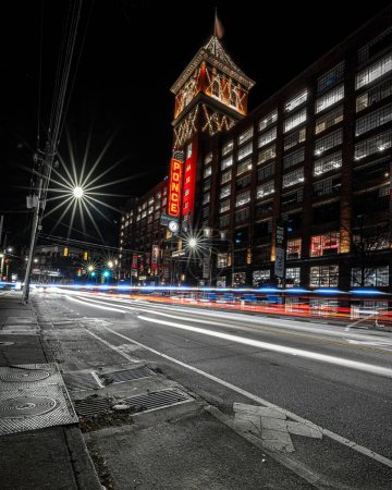Photo for A long exposure shot of traffic lights with the illuminated Ponce City Market in Atlanta at night - Royalty Free Image
