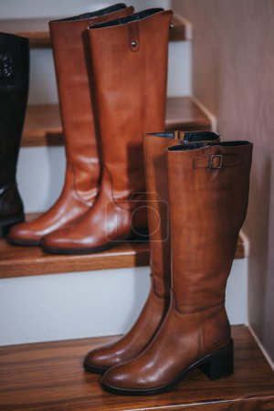 Téléchargez les photos : Un plan vertical de bottes en cuir sur un escalier en bois - en image libre de droit