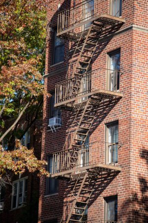 Photo for A vertical shot of a fire escape staircase of a brick building in New York, United States. - Royalty Free Image