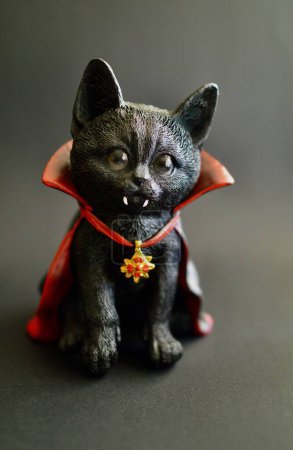Téléchargez les photos : Une figurine d'un chat noir vampire avec une cape rouge - en image libre de droit