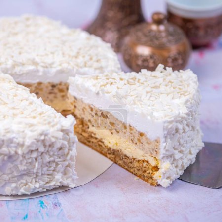 Foto de Un primer plano del pedazo de pastel de queso de coco cubierto con coco rallado blanco con un fondo borroso - Imagen libre de derechos
