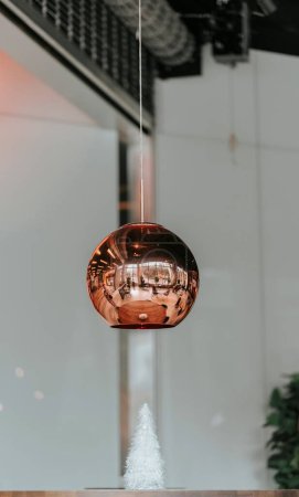 Téléchargez les photos : Plan vertical d'une lampe moderne en cuivre chromé suspendue dans un café - en image libre de droit