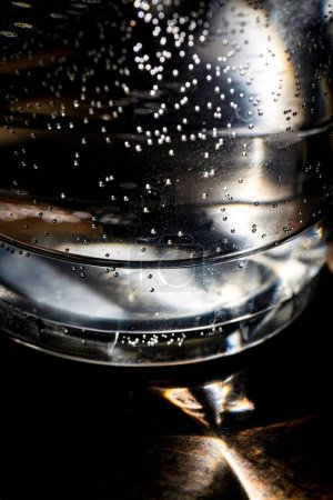 Photo for A closeup of a backlit abstract view of a plastic cup full of water - Royalty Free Image