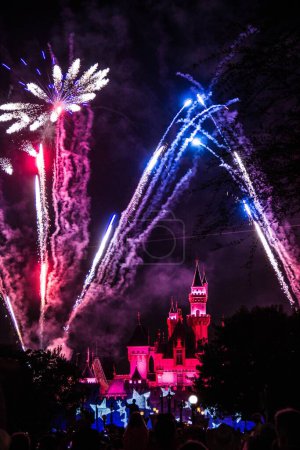 Foto de Una imagen de fuegos artificiales y un castillo en las luces rojas en Disney Land de Los Ángeles por la noche. - Imagen libre de derechos
