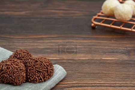 Photo for A closeup of chocolate Brazilian Brigadeiro and Beiginho on a wooden table with copy space - Royalty Free Image
