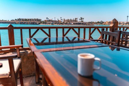 Téléchargez les photos : Un plan sélectif d'un lagon à El Gouna en Egypte, une vue depuis une véranda avec une table et une tasse floue sur - en image libre de droit