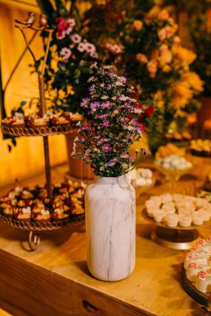 Foto de Una mesa de madera con dulces y flores frescas y sabrosas - Imagen libre de derechos