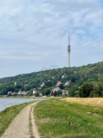 Téléchargez les photos : Plan vertical d'un sentier au bord d'un lac sur le fond du Fernsehturm Dresde - en image libre de droit
