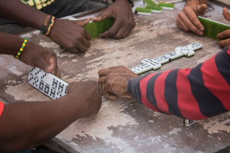 Foto de Un primer plano de manos negras latinas jugando dominó en el barrio de La Marina Matanzas, Cuba - Imagen libre de derechos