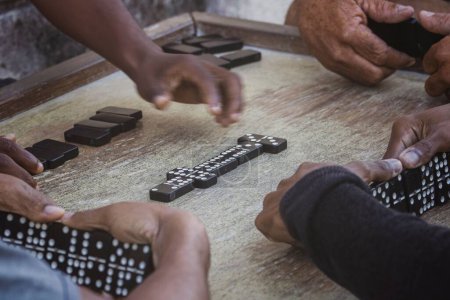 Eine Nahaufnahme schwarzer Latinos, die Dominosteine in der Nachbarschaft von La Marina Matanzas, Kuba, spielen
