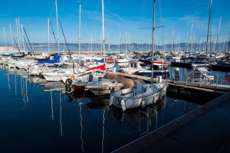 Foto de Barcos atracados en un puerto cerca de Lausana Suiza con un cielo azul y paisaje marino en el fondo - Imagen libre de derechos