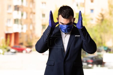 Photo for A young Muslim man praying outdoors while wearing a protective mask and gloves - Royalty Free Image