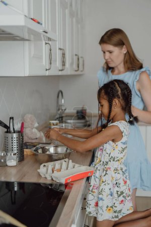 Photo for The Hispanic mother and daughter cooking in the kitchen - Royalty Free Image