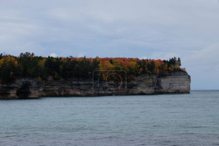 Foto de Una vista panorámica de un acantilado rocoso cubierto de hermosos árboles de otoño de colores en el mar durante el otoño - Imagen libre de derechos