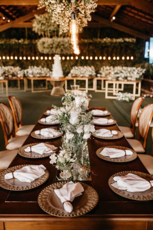 Téléchargez les photos : Un plan vertical d'une table de mariage dans un restaurant intérieur avec des meubles en bois - en image libre de droit