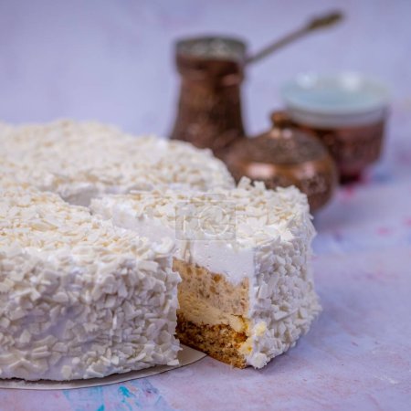 Photo for A closeup of the piece of coconut cheesecake covered with white grated coconut with a blurry background - Royalty Free Image