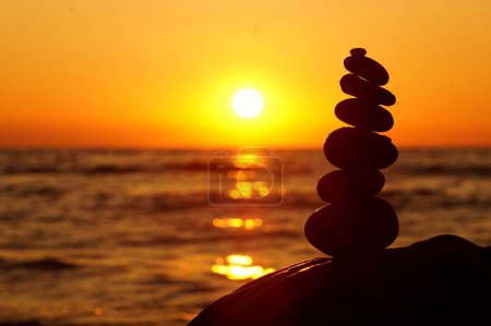 Téléchargez les photos : Un gros plan de pierres zen sur fond de coucher de soleil orange - en image libre de droit