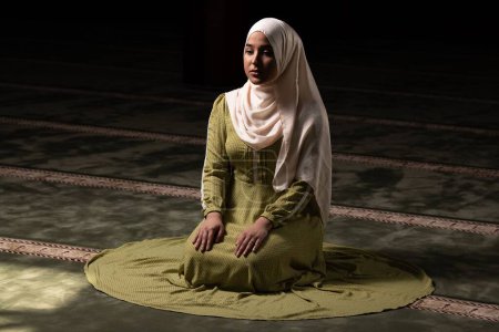 Foto de Un retrato de una hermosa mujer musulmana humilde rezando en paz en una mezquita - Imagen libre de derechos