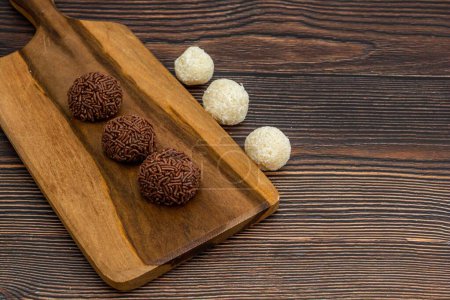 Photo for A top view of chocolate Brazilian Brigadeiro and Beiginho on a cutting board with copy space - Royalty Free Image