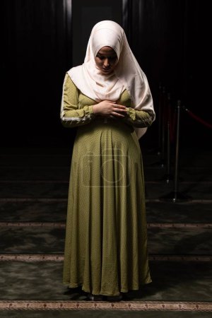 Téléchargez les photos : Plan vertical d'une musulmane caucasienne portant le long hijab islamique Khimar à l'intérieur d'une mosquée - en image libre de droit