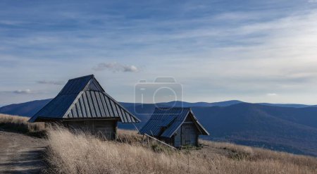 Téléchargez les photos : Une grange en bois avec les montagnes Bieszczady dans le dos capturé pendant la lumière du jour - en image libre de droit