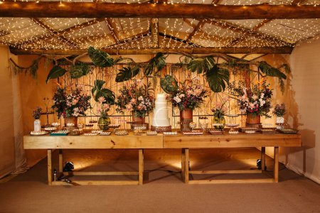 Téléchargez les photos : Une table en bois avec beaucoup de plantes, un gâteau et des bonbons frais - en image libre de droit