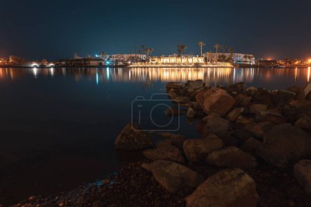 Téléchargez les photos : Une belle longue exposition de la lagune El Gouna avec vue sur un hôtel la nuit - en image libre de droit