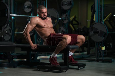 Foto de Un hombre atractivo de buen aspecto caucásico con el cuerpo muscular haciendo ejercicio en el gimnasio - Imagen libre de derechos