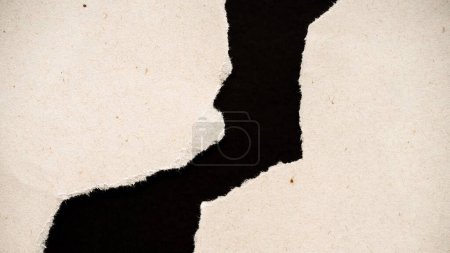 Foto de Una macro toma de un papel roto con bordes ásperos, sobre un fondo negro, el concepto de un mapa geográfico - Imagen libre de derechos