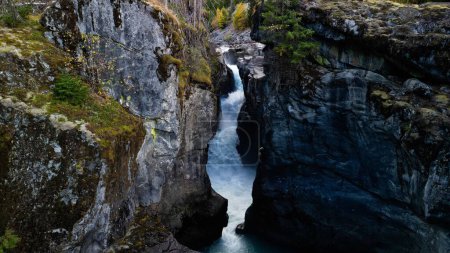 Foto de Una vista impresionante de una cascada en el Parque Provincial de Nairn Falls, Canadá, rodeado de montañas rocosas y bosque siempreverde - Imagen libre de derechos