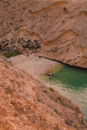 Téléchargez les photos : Une belle vue d'un bateau sur un rivage avec des rochers au lever du soleil - en image libre de droit