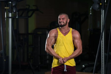 Foto de Un retrato de un joven sano caucásico posando en el gimnasio y flexionando sus músculos - Imagen libre de derechos