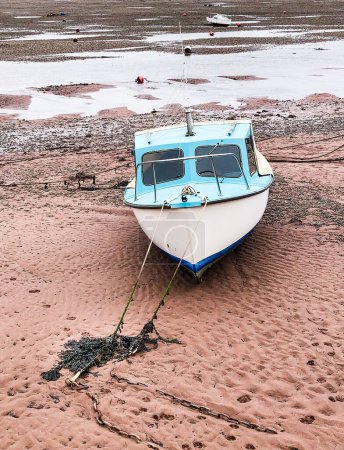 Téléchargez les photos : Plan vertical d'un bateau bleu échoué sur la rive de la rivière Teign à marée basse au village de Shaldon, Devon - en image libre de droit