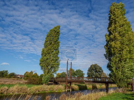 Téléchargez les photos : Une vue imprenable sur le paysage avec une rivière Vechte et un pont entouré de végétation verte - en image libre de droit