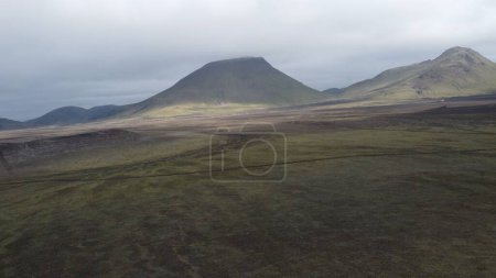 Foto de Un disparo de dron de la montaña volcánica y el campo de lava negro bajo el cielo nublado en Landmannalaugar, Islandia - Imagen libre de derechos