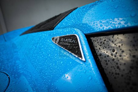 Foto de Un primer plano de la parte trasera del automóvil Lotus mojado y azul con un signo de "PRIMERA EDICIÓN" en la fábrica - Imagen libre de derechos