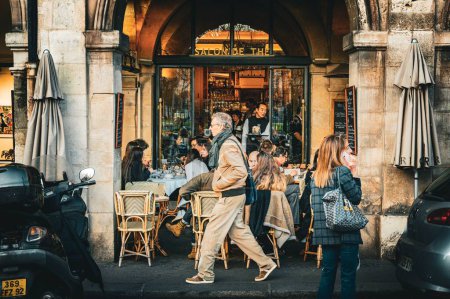 Téléchargez les photos : Les salons de thé bondés de Paris avec les passants - en image libre de droit