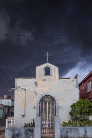 Téléchargez les photos : Plan vertical d'une église avec une énorme croix et une tempête en arrière-plan - en image libre de droit