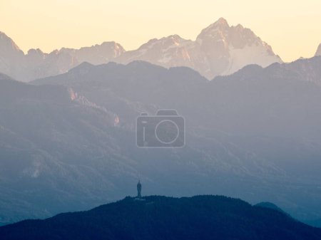 Téléchargez les photos : Un beau cliché de la tour Pyramidenkogel avec le fond des paysages des Alpes juliennes en Carinthie, Autriche - en image libre de droit