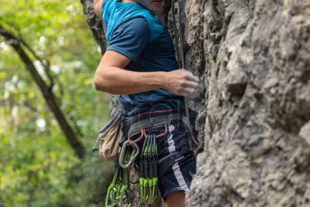 Foto de Un joven escalando el acantilado. Escalada en roca, concepto deportivo. - Imagen libre de derechos