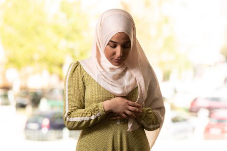 Téléchargez les photos : Une femme musulmane en hijab beige et vêtements traditionnels priant pour Allah - en image libre de droit