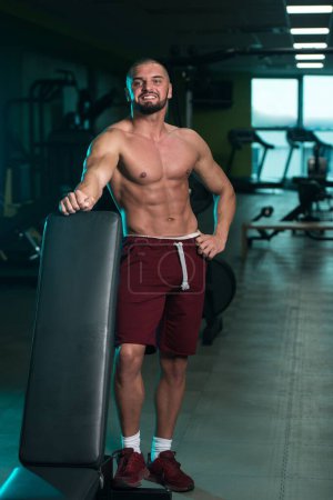 Foto de Un guapo caucásico y atractivo joven masculino con cuerpo muscular relajante en el gimnasio - Imagen libre de derechos